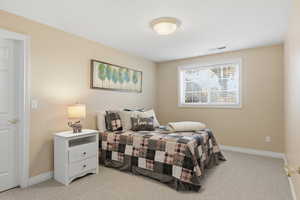 Bedroom with light carpet and baseboards