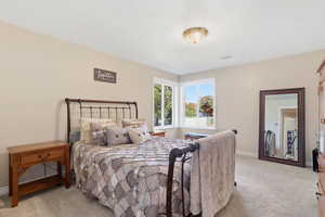Bedroom featuring light carpet and baseboards