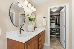 Bathroom featuring double vanity and a walk in closet