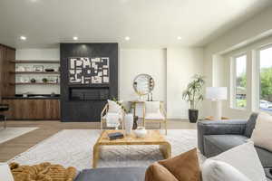 Living area featuring light wood-type flooring, recessed lighting, and a high end fireplace