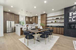 Dining room with light wood finished floors and recessed lighting