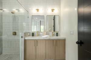 Bathroom with double vanity and a stall shower