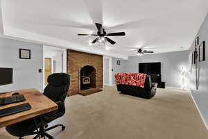 Home office featuring light colored carpet and a ceiling fan