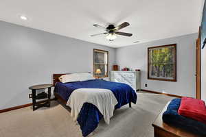 Carpeted bedroom with baseboards and a ceiling fan