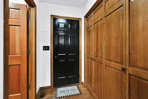 Doorway featuring wood finished floors and baseboards