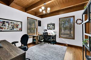 Office area featuring wood-type flooring, a chandelier, and a wood ceiling with exposed beams