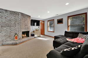 Living room with a fireplace, carpet, and recessed lighting