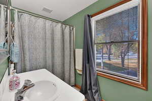 Full bathroom with a shower with curtain and vanity