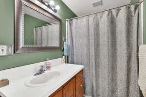 Full bathroom with vanity and a shower with shower curtain