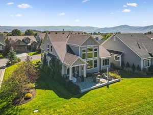 Back of house with board and batten siding, a mountain view, roof with shingles, a patio, and outdoor lounge area