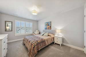 Bedroom with light colored carpet and a textured ceiling