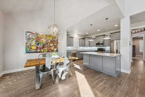 Dining area featuring a chandelier, dark wood-type flooring, lofted ceiling, and recessed lighting