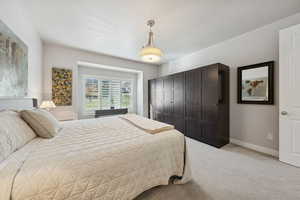 Bedroom with light colored carpet and a closet
