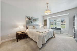 Bedroom featuring light colored carpet and baseboards