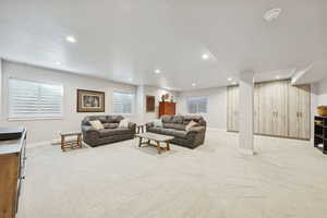 Living area featuring light colored carpet, recessed lighting, and plenty of natural light