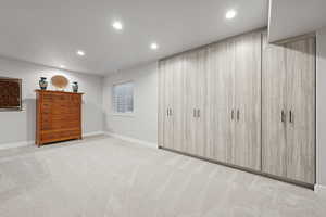 Unfurnished bedroom with light colored carpet and recessed lighting