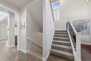 Staircase with healthy amount of natural light and wood finished floors