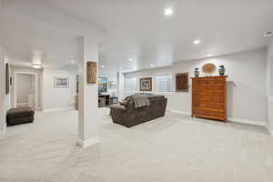 Living area featuring light colored carpet and recessed lighting