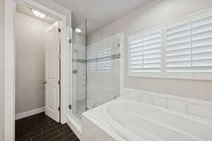 Bathroom with a shower stall, a bath, and wood tiled floors