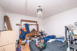 Bedroom with wood finished floors and a chandelier