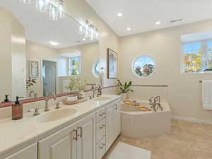 Bathroom with double vanity, a garden tub, recessed lighting, and light tile patterned floors