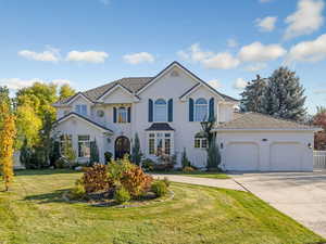 View of front facade featuring concrete driveway and an attached garage