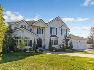 View of front of home with a front lawn, driveway, and an attached garage