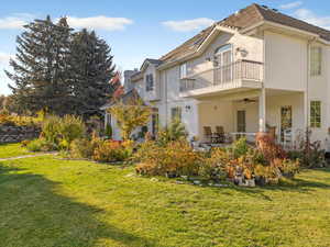 Rear view of property featuring ceiling fan, a yard, brick siding, and a patio