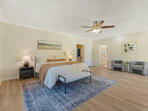 Bedroom with light wood-style floors, crown molding, and ceiling fan