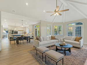Living room featuring french doors, beamed ceiling, light wood-type flooring, high vaulted ceiling, and recessed lighting