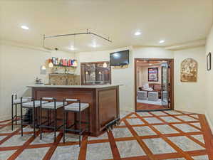 Indoor dry bar with inlaid floor details, decorative light fixtures, recessed lighting, light stone counters, and open shelves