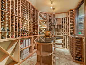 Wine cellar featuring a textured ceiling and light stone finish flooring
