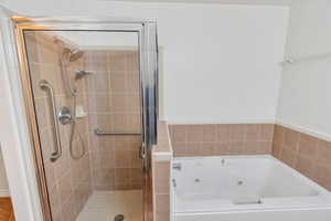 Full bath with a stall shower and a whirlpool tub