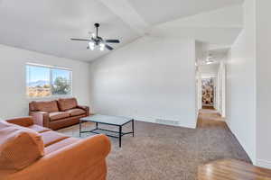 Carpeted living area with lofted ceiling, a mountain view, and ceiling fan