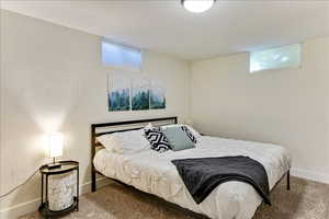 Bedroom featuring carpet flooring, a textured ceiling, and a textured wall