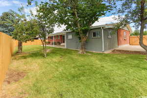 Rear view of house with a patio area and a fenced backyard