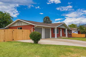 Ranch-style home with brick siding, a shingled roof, driveway, a garage, and a gate