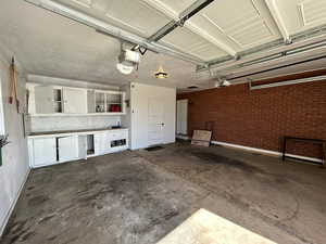 Garage with a garage door opener and baseboards