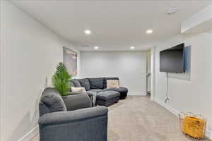 Carpeted living room with recessed lighting