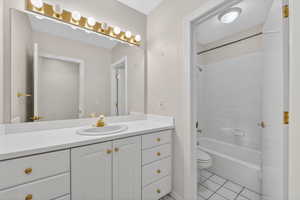 Bathroom featuring vanity, shower / tub combination, and light tile patterned floors