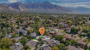 Aerial view of residential area with a mountainous background and property parcel outlined