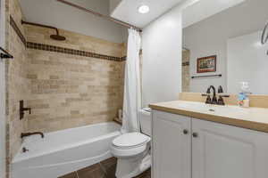 Bathroom with shower / tub combo with curtain, vanity, dark tile patterned floors, and recessed lighting