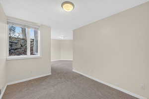 Spare room with carpet and baseboards