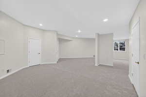 Below grade area with light carpet and recessed lighting