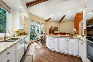 Kitchen featuring beam ceiling, white cabinets, a peninsula, dark wood finished floors, and recessed lighting