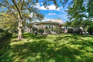 Back of house featuring stucco siding and a lawn