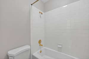 Bathroom featuring washtub / shower combination and toilet