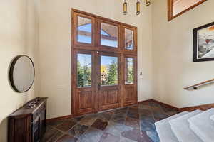 Foyer with a high ceiling and stone tile flooring