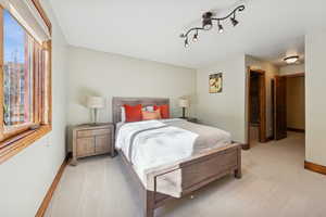 Bedroom with light colored carpet and baseboards
