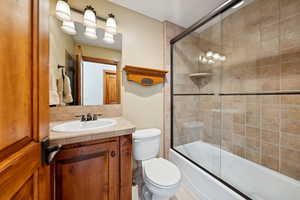 Bathroom with vanity and enclosed tub / shower combo